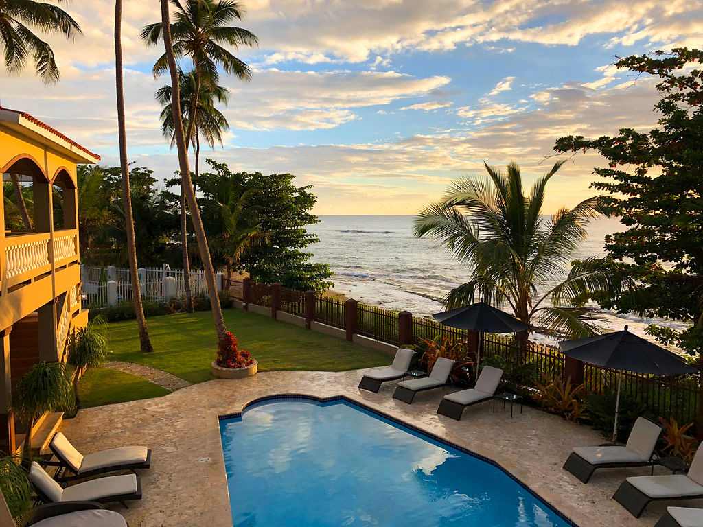 Pool deck with palms silhouetted against the Rincón sunset